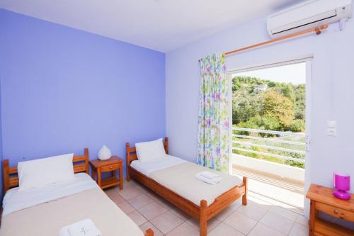 una camera con due letti e una finestra di Kolios Seaside Apartments a Kolios