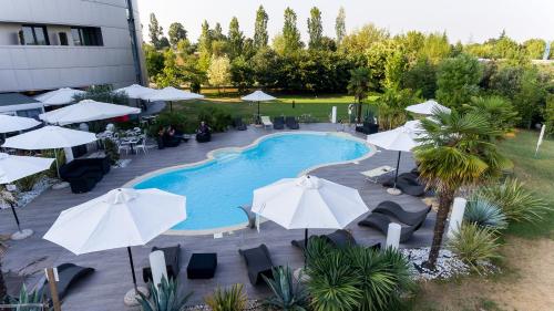 an overhead view of a swimming pool with umbrellas at Amati' Design Hotel in Zola Predosa