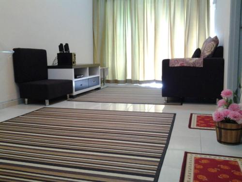 a living room with two chairs a couch and a television at Alisa Homestay in Sungkai