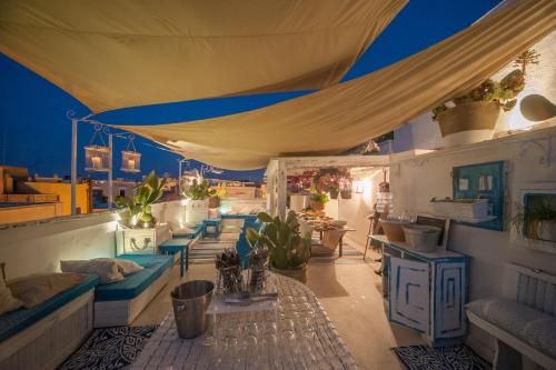 a patio with blue chairs and a large tent at Portadamare in Trani