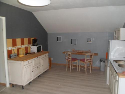 cocina con mesa y mesa pequeña con sillas en L'etape de St Hilaire La Gravelle, en Saint-Hilaire-la-Gravelle