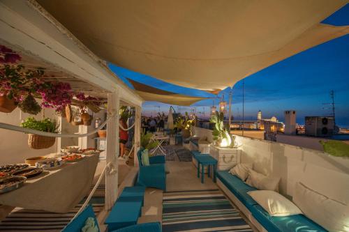 a balcony with blue chairs and tables on a roof at Portadamare in Trani