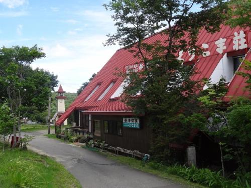 a building with a red roof next to a road at Shinyu Onsen Kurikomaso in Kurihara
