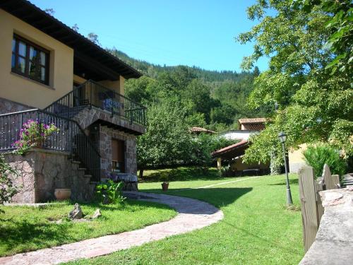 a house with a staircase next to a yard at Ribera del Sella in Cangas de Onís