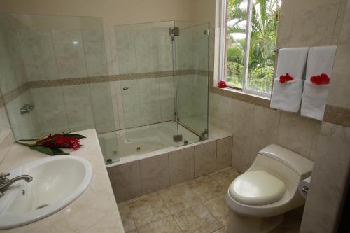 a bathroom with a sink and a toilet and a tub at Palm Coast Luxury Rentals in Esterillos Este