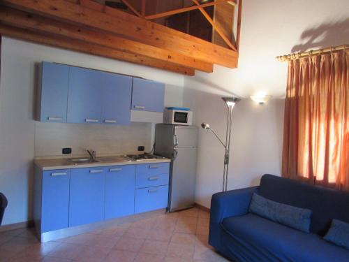 a kitchen with blue cabinets and a blue couch at Private Apartments 1 minute to the pool & beach Santa Maria #74B #86 in Santa Maria