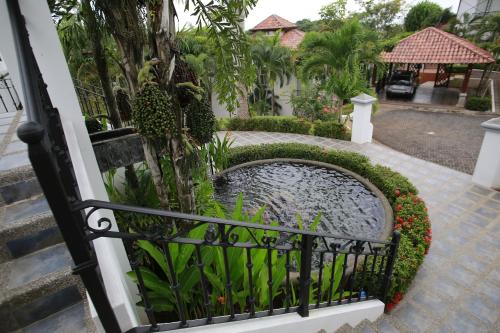 a garden with a pond in a fence at Palm Coast Luxury Rentals in Esterillos Este