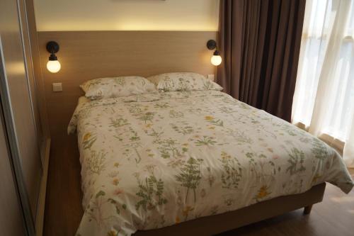 a bedroom with a bed with a floral comforter at Sentrio Pandan Kuala Lumpur in Kuala Lumpur