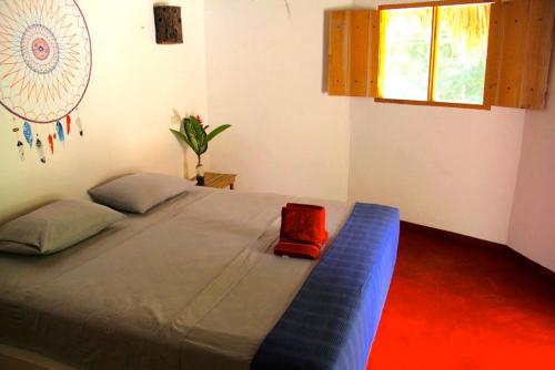 a bedroom with a blue bed with a red box on it at Finca Carpe Diem Ecolodge in Minca