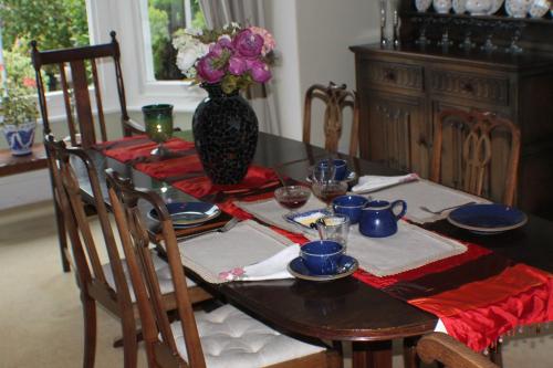 a dining room table with a vase of flowers on it at Baytree in Minehead