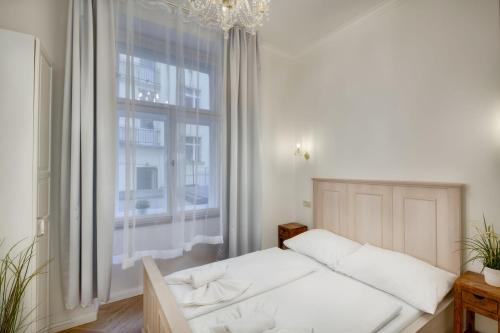 a bedroom with a bed and a large window at Dušní 13 - Old Town Apartment in Prague