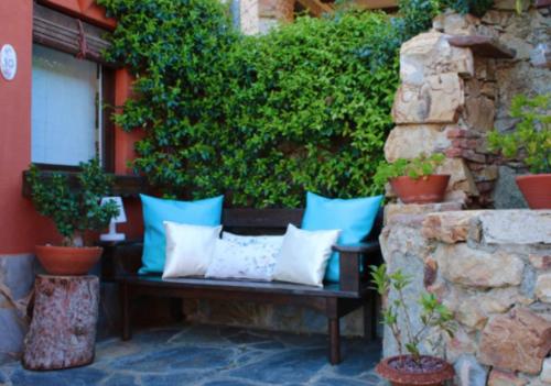 a bench with blue and white pillows on a patio at Casa Rosa Garden House in Santa Cristina d'Aro