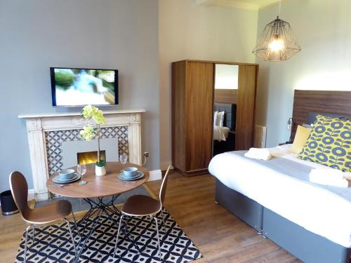 ein Schlafzimmer mit einem Bett und einem Tisch mit Stühlen in der Unterkunft Claremont Apartments, Leeds City Centre in Leeds