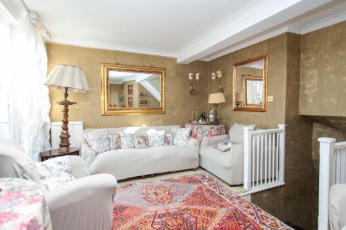 a living room with white couches and a mirror at ItalianFlat - Oakley in London