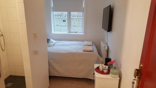 a small bedroom with a bed and a window at Finna Hótel in Hólmavík