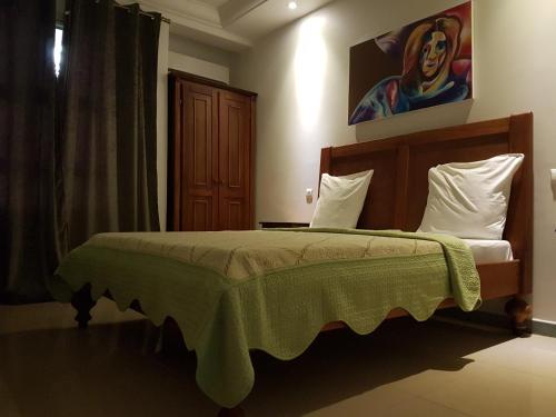 a bedroom with a bed and a painting on the wall at Tchero Appartement 2 in Douala
