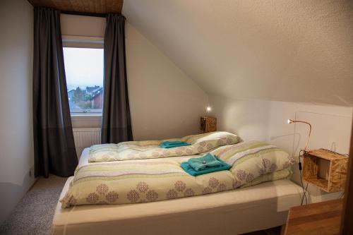 a bedroom with a bed with a window at Tora Guesthouse in Tórshavn