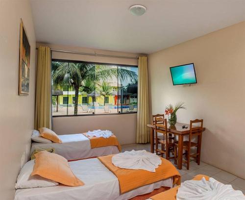 Habitación de hotel con 2 camas y ventana en Hotel Real Comandatuba en Ilha de Comandatuba