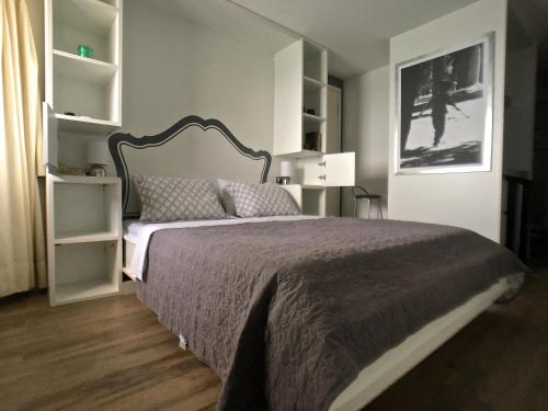 a bedroom with a large bed and white shelves at Beira Mar Suite in Fortaleza