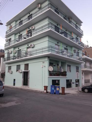 a large white building with balconies on the side of it at Hellas Palace Rooms CENTER in Sparti