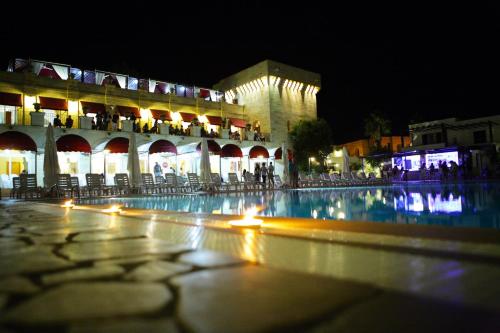 un edificio con una piscina d'acqua di notte di Messapia Hotel Resort a Leuca