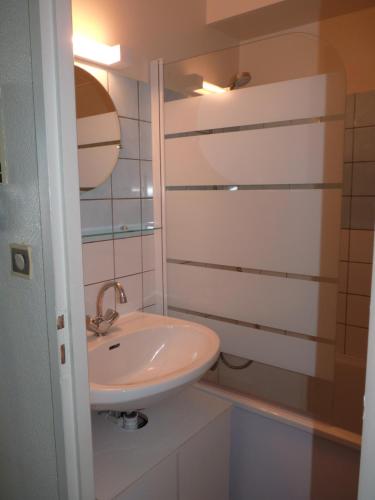 une salle de bain blanche avec un lavabo et une douche dans l'établissement Studio les bleuets, à Gérardmer