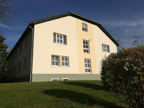 a large building on top of a grass field at Hotel & Restaurant Bergfried in Saalfeld