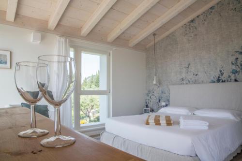 a bedroom with a bed and two wine glasses on a table at Ca Muretta Relais in Bardolino