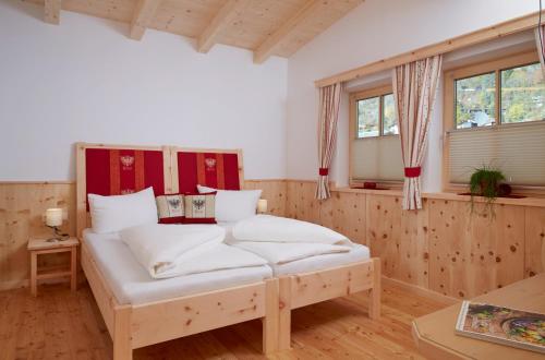 um quarto com uma cama com lençóis brancos em Ferienhaus Zangerl em Oetz