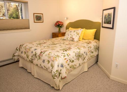 a bedroom with a bed with a floral bedspread at Gardenside Bed and Breakfast in Anchorage