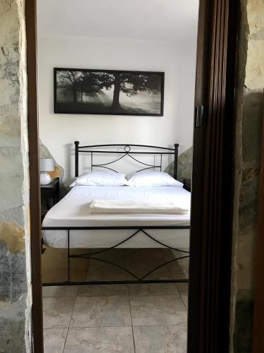 a bedroom with a bed with a black frame at Gourgiana Apartments in Andritsaina