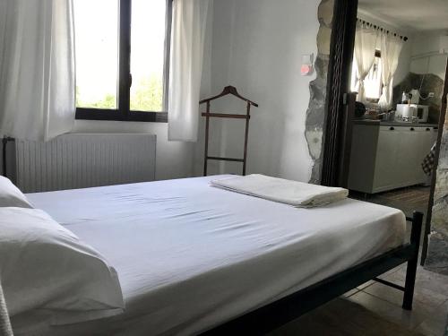 a white bed in a room with a window at Gourgiana Apartments in Andritsaina
