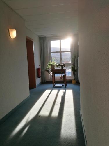 an empty room with a table and a window at Hotel & Restaurant Bergfried in Saalfeld