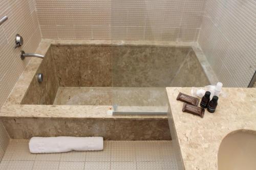 a bath tub in a bathroom with a sink at Aguas Mornas Palace Hotel in Santo Amaro da Imperatriz