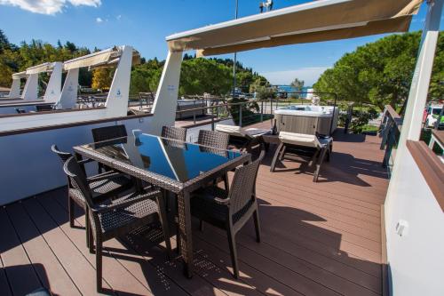 a deck on a boat with chairs and a table at Floating Sea Houses MARINA LUX in Portorož
