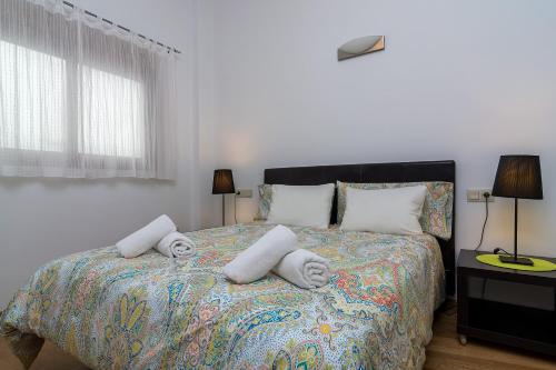 een slaapkamer met een bed met handdoeken erop bij DescubreHome Postigo Inner Patio in Sevilla