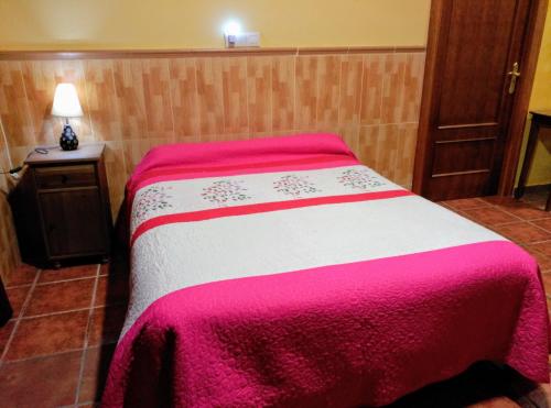 1 dormitorio con 1 cama con manta roja y blanca en La Derrubiá, en Villamalea