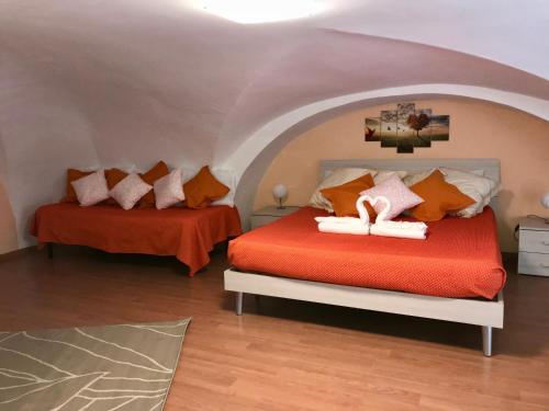 a bedroom with two beds with orange sheets at Casa Kitea in Catania