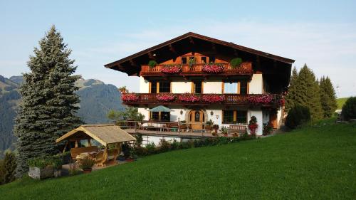 a house on the side of a hill with flowers at Hof Hamoos in Kitzbühel