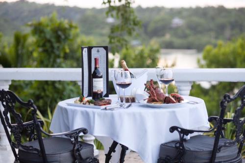 a table with a plate of meat and wine glasses at Jamaica Palace Hotel in Port Antonio