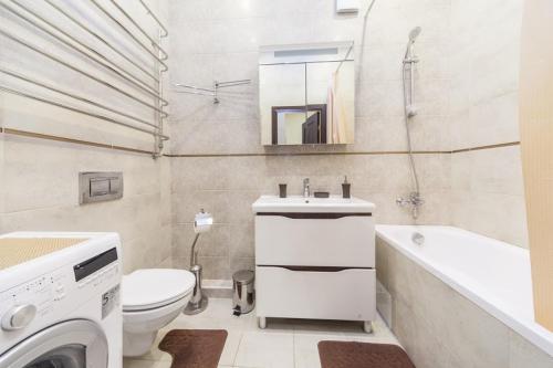 a bathroom with a toilet sink and a washing machine at center, Apartment on Deribasovskaya 10 in Odesa