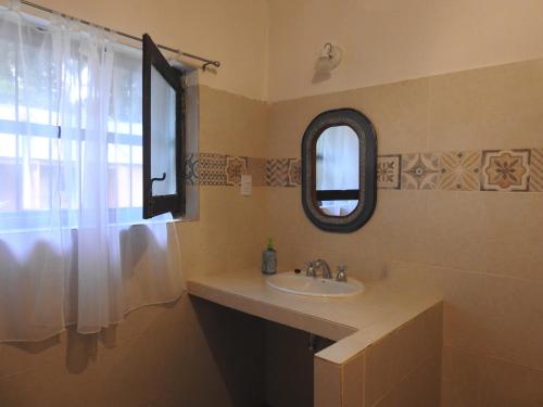 W łazience znajduje się umywalka i lustro. w obiekcie Posada de las Huellas w mieście Loreto