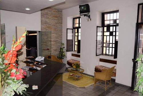 a lobby with a desk and chairs and windows at Hotel Don Juan in Salvador