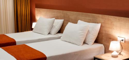 two beds with white pillows in a hotel room at Babaneuris Marani in Babaneuri