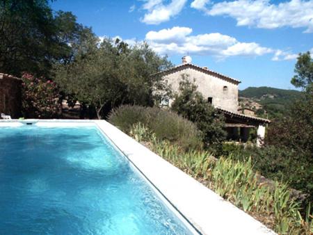 a large swimming pool in front of a house at Gîtes du Mas Icard in Anduze