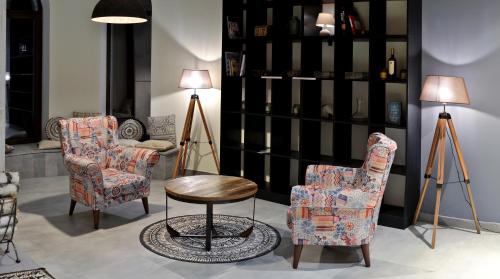 a room with two chairs and a table and lamps at Babaneuris Marani in Babaneuri