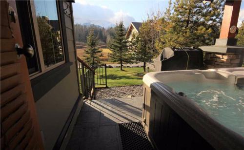 un bain à remous sur la terrasse couverte d'une maison dans l'établissement Pinnacle Ridge Chalets by Fernie Lodging Co, à Fernie