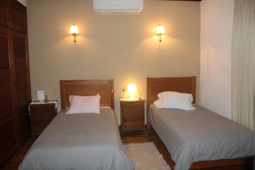 テーラス・デ・ボウロにあるBem Sonharのベッド2台 壁にランプ2つが備わる客室です。