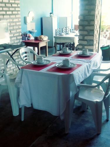a white table with plates and cups on it at Pousada Cruzeiro dos Anjos in Tabatinga