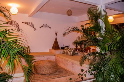 a living room with a couch and two palm trees at Residence Bons Ventos Jeri in Jericoacoara